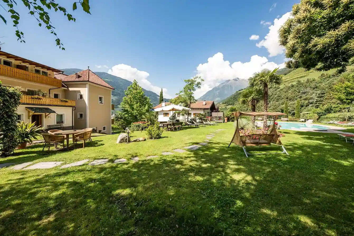 Mediterrane Gartenanlage mit Liegewiese, Schaukel und Palmen